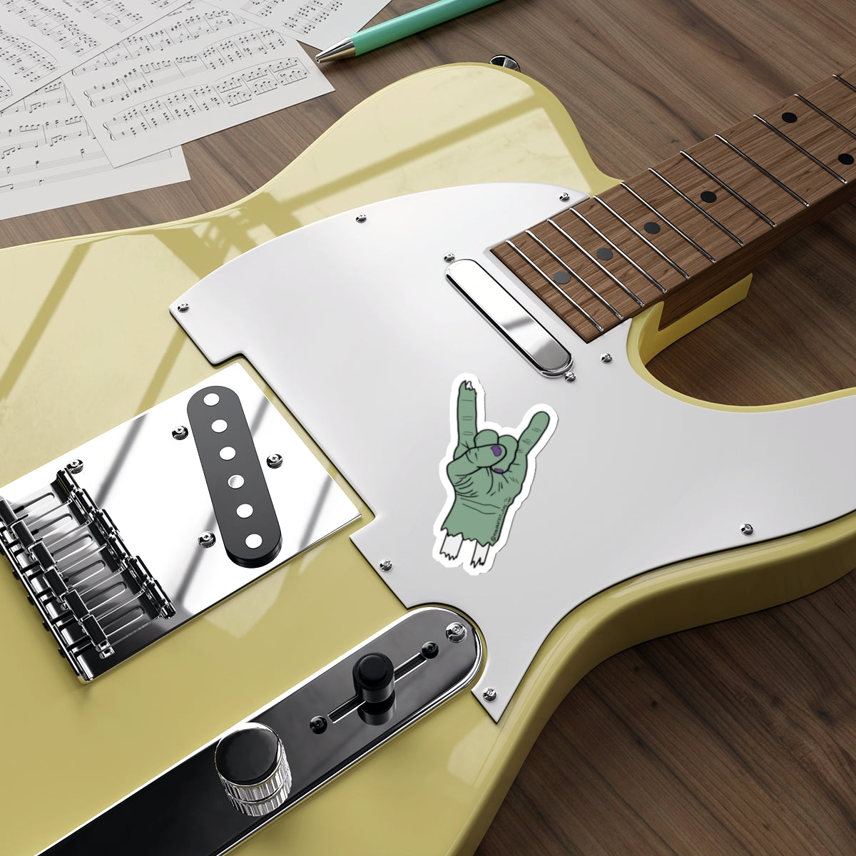 Yellow electric guitar with a white pickguard on a wooden surface